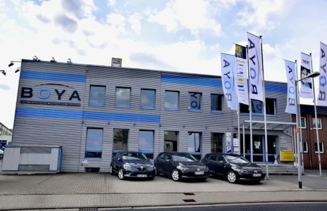 Außenansicht einer modernen Kfz-Werkstatt mit Reparaturannahme und Lackiererei.